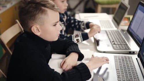 Children Studying with Laptops in an Indoor Setting