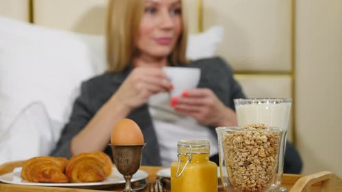 Young Pretty Successful Business Woman Having Breakfast in Luxury Hotel Room