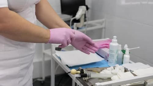 Medical Professional Putting on Pink Protective Gloves