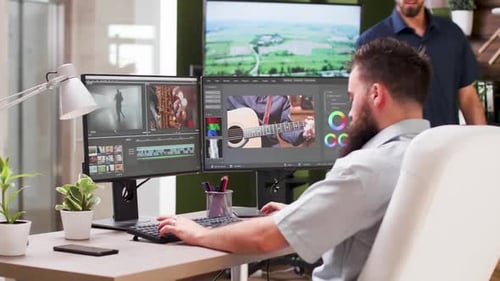 Two Men Collaborating on Video Editing in Office