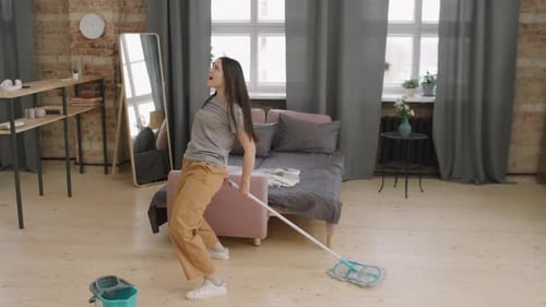 Mujer bailando y limpiando piso