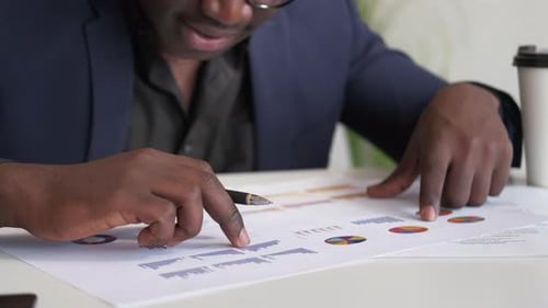 Man Reviews Company Data at Desk