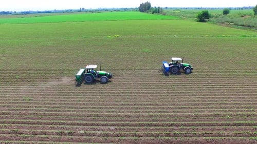 Tractors Pouring Fertilizer Into The Field