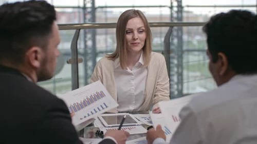 Business Meeting with Graphs and Financial Reports