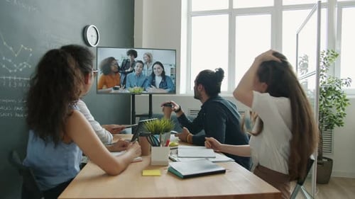 Group of Businesspeople Discussing Ideas with Colleagues During Online Video Call in Office