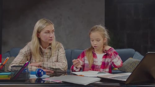 Woman Helps Child with Homework at Home