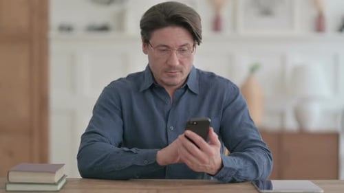 Attractive Man using Smartphone in Office