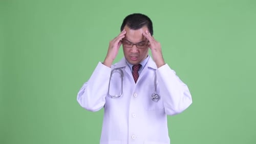 Doctor Massaging Temples with Headache on Green Screen