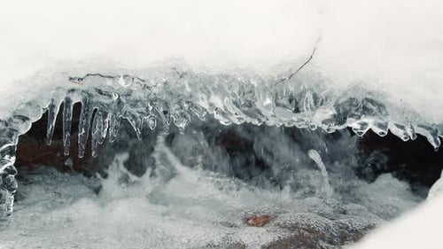 River Water Flowing Under Winter Powder Snow Close Up