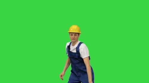 Young Construction Worker in Yellow Hardhat Break Dancing Looking at Camera on a Green Screen Chroma