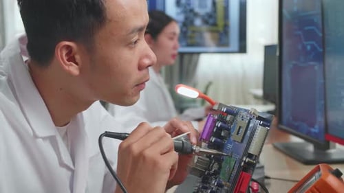 Engineer Soldering Circuit Board in Technology Workplace