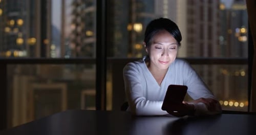 Woman Using Phone at Table with City View