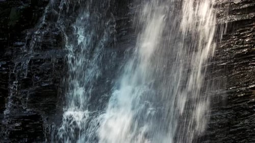 Small Cliffy Mountain Waterfall on a Sunny Day