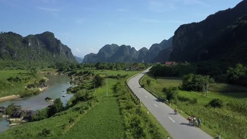 Upper View Bikers Ride Bicycles Along Road Near Narrow River