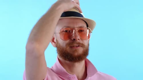 Stylish Man Putting on Hat and Smiling