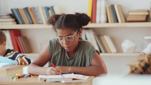 Happy Girl Studying at School Desk, Smiling