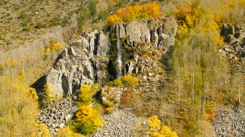 Luftaufnahme über den Wasserfall auf der Felsklippe. Gelbe Bäume sind da. Herbst-Saison