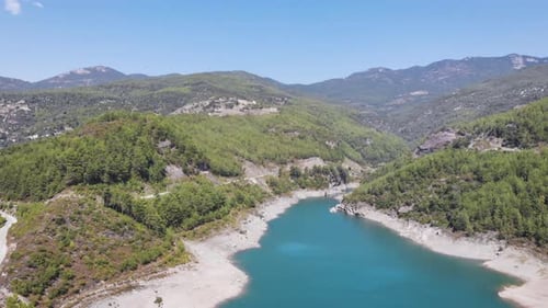 Beautiful mountain lake with clear green water and large stones on shore aerial view