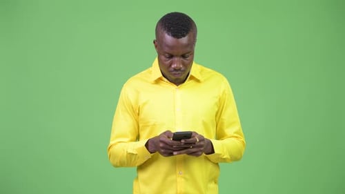 Man Smiling and Using a Smartphone