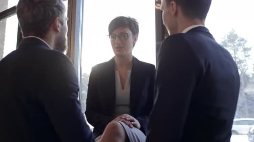 Three Adults Talking Next to Bright Window