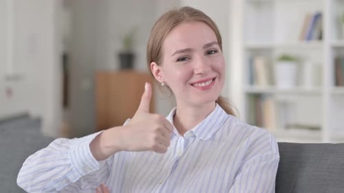 Young Woman Gives Thumbs Up Indoors Close-Up