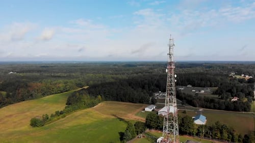 Cell phone tower in rural country setting orbiting drone.