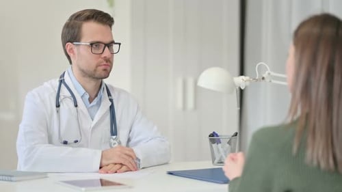 Male Doctor Discussing Medical File with Patient