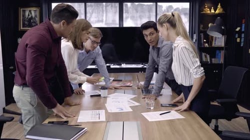 Business Team Discussing Charts at Conference Table