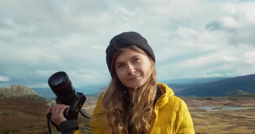 Happy Woman with Camera in Mountainous Landscape