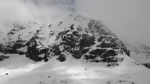 High Altitude Rocky Snowy Dome Mountain Peak in Cloudy Winter