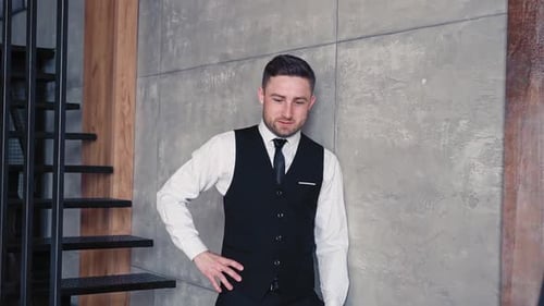 Man in Vest Standing by Concrete Wall