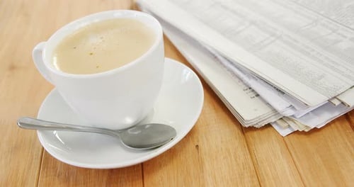 Coffee and Newspaper on a Wooden Table