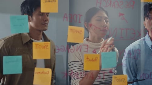 Asia businesspeople stand behind transparent glass wall listen manager pointing progress work.