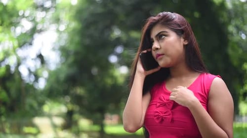 A beautiful happy and cheerful girl talks on phone with her friend and laughs, a mobile phone addict