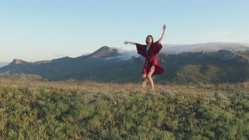 Woman Dances Barefoot in a Mountain Field