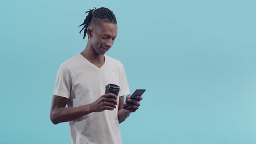 Young Adult Using Smartphone and Drinking Beverage
