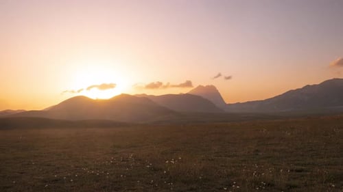 Time lapse: clouds moving in the sky, sunset view point over rocky mountains, highlands and pastures