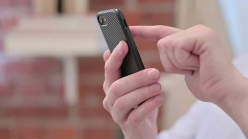 Close Up of Casual Young Man Using Smartphone