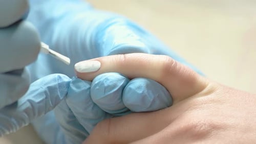Manicurist Applying White Nail Polish Close Up
