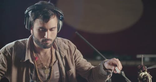 Drummer playing on electronic drum set in a recording studio