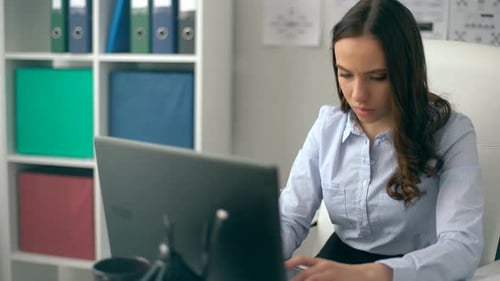 Jovem mulher usando computador portátil no local de trabalho