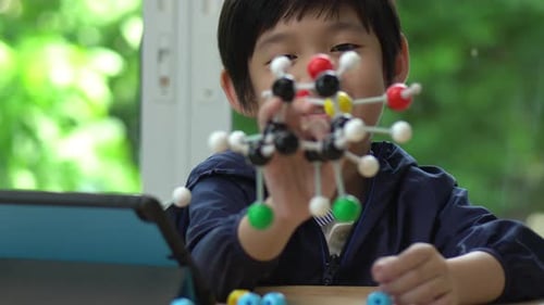 Young Boy Building Colorful Molecular Model at Home