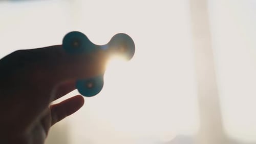 Joven juega con una ruleta contra la brillante luz del sol