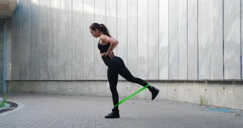 Woman Exercising with Resistance Band Outdoors