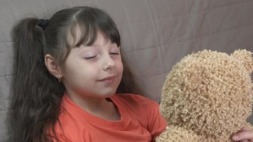 Girl Hugging Teddy Bear Cuddling with Toy Indoors