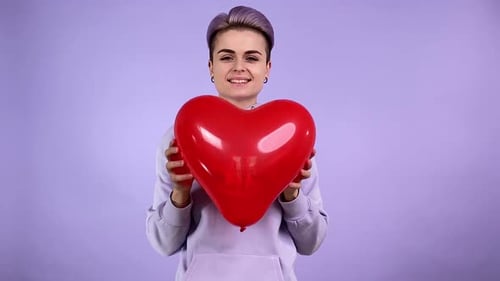 Smiling Woman Holding Red Heart Balloon