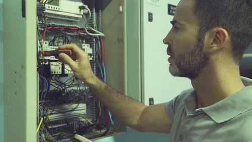 Electrician Repairing Electrical Box Using Tablet