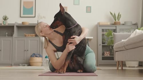 Woman Hugging Her Doberman Dog Indoors