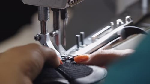Hands Sewing Black Leather on Machine Close Up