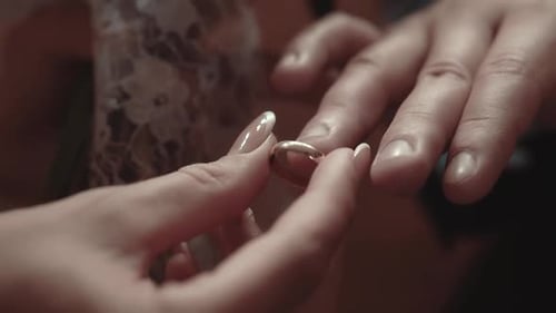 Die Braut legt während der Hochzeitszeremonie einen Verlobungsring auf den Finger des Bräutigams